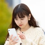 スマホで連絡を取る女性