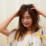 頭を抱えて悩む女性